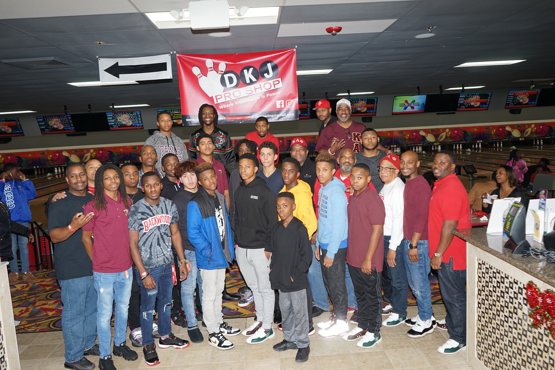 Large group of people posing for picture in bowling alley
